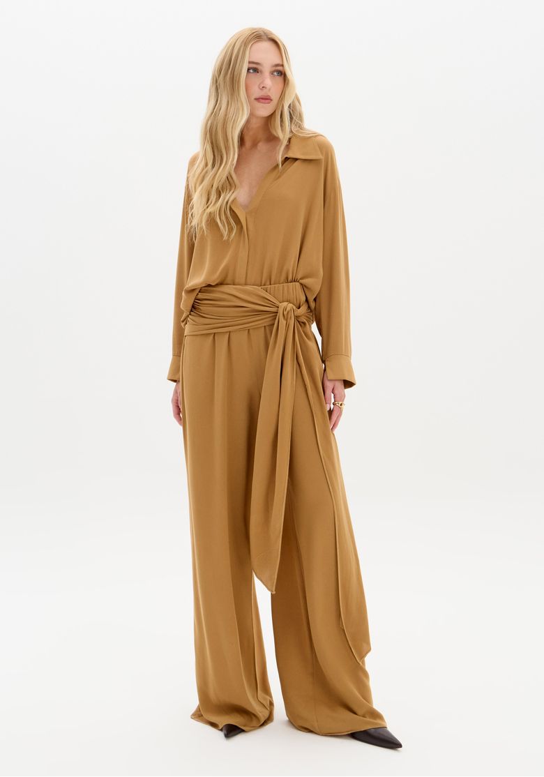 Vista frontal completa com calça reta solta bege em viscose 100% e amarração na cintura, modelo em pose frontal.
