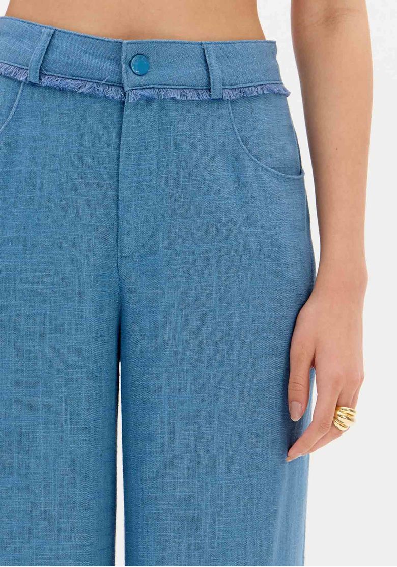 Vista traseira da calça wide leg azul mostrando cós com passantes e caimento solto até a barra
