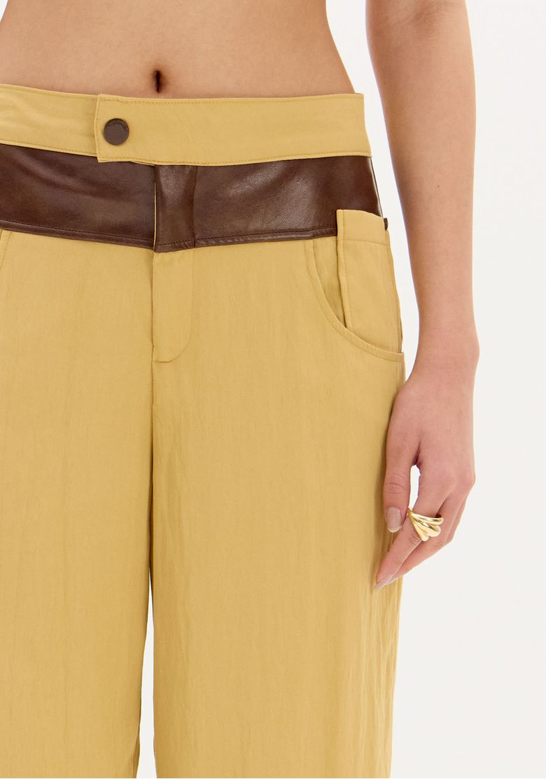 Vista traseira da calça wide leg bicolor destacando os bolsos embutidos.
