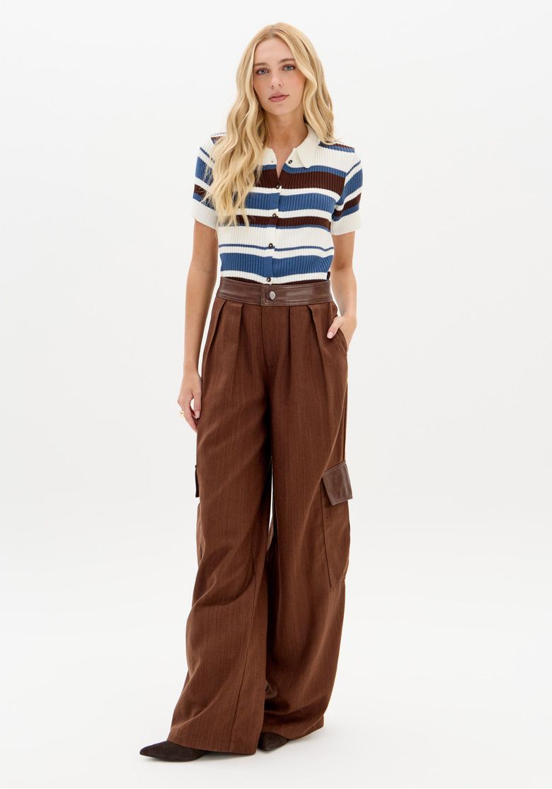 Modelo usando a calça wide leg marrom com uma blusa listrada.