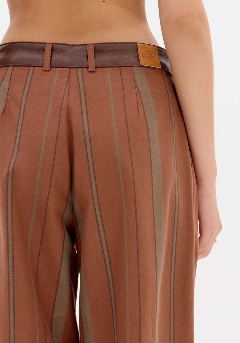 Visão traseira do conjunto listrado: blazer com recorte nas costas e calça reta mostrando caimento e comprimento