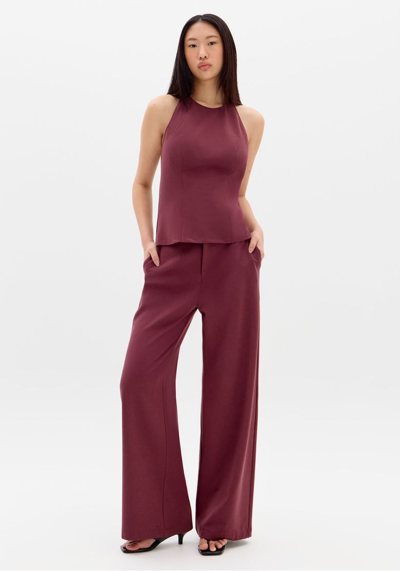 Modelo frontal vestindo calça full length feminina vermelha com cintura média, perna ampla e bolsos laterais embutidos