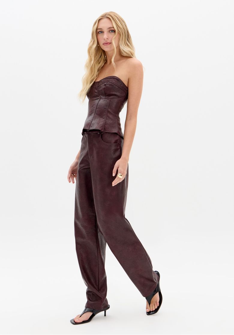 Modelo vestido com calça barrel vinho em couro sintético PU, vista lateral, cintura média e caimento longo.