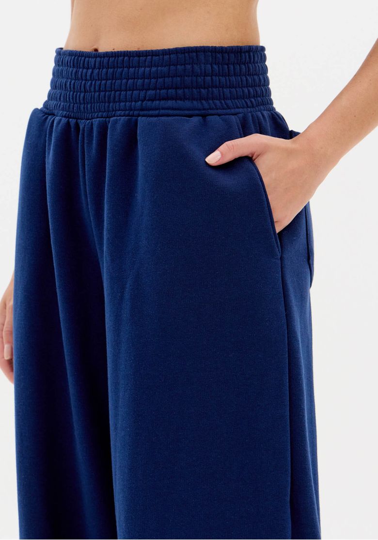 Close do Bolso Lateral da Calça Moletom Azul com Mão Apoiada, Mostrando Funcionalidade e Tecido de Malha Pesada
