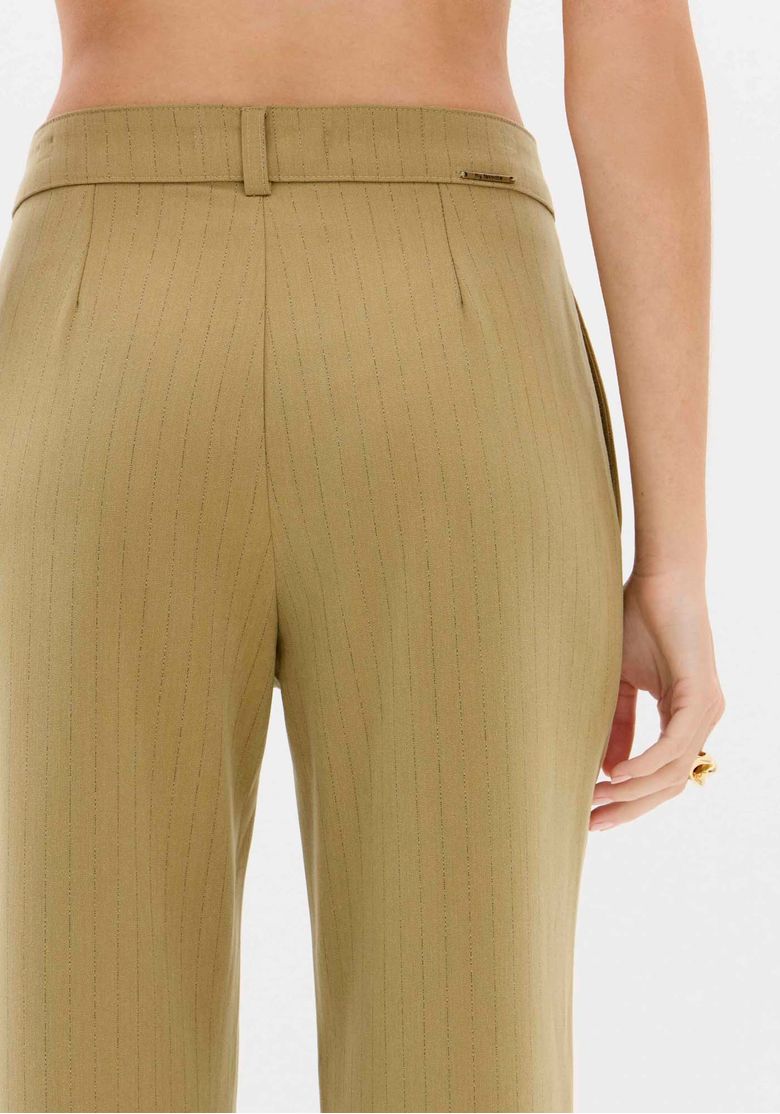 Close do cós traseiro da calça risca de giz verde com passantes e detalhe do tecido plano pesado