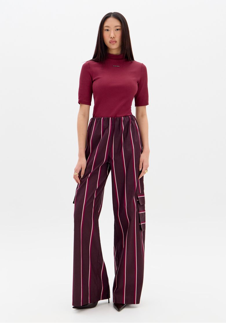 Detalhe do cós elástico da calça wide leg listrada em vermelho.
