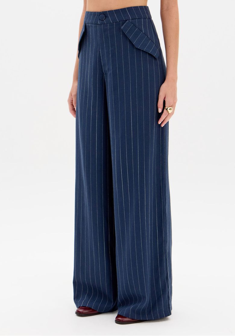 Close da cintura da calça azul risca-de-giz mostrando botão forrado e bolsos com aba - detalhe alfaiataria