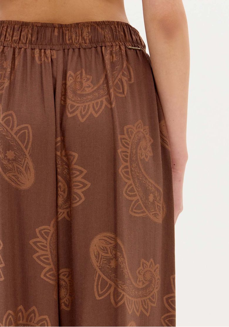 Close do cós elástico traseiro da calça marrom estampada paisley, detalhe do tecido e textura