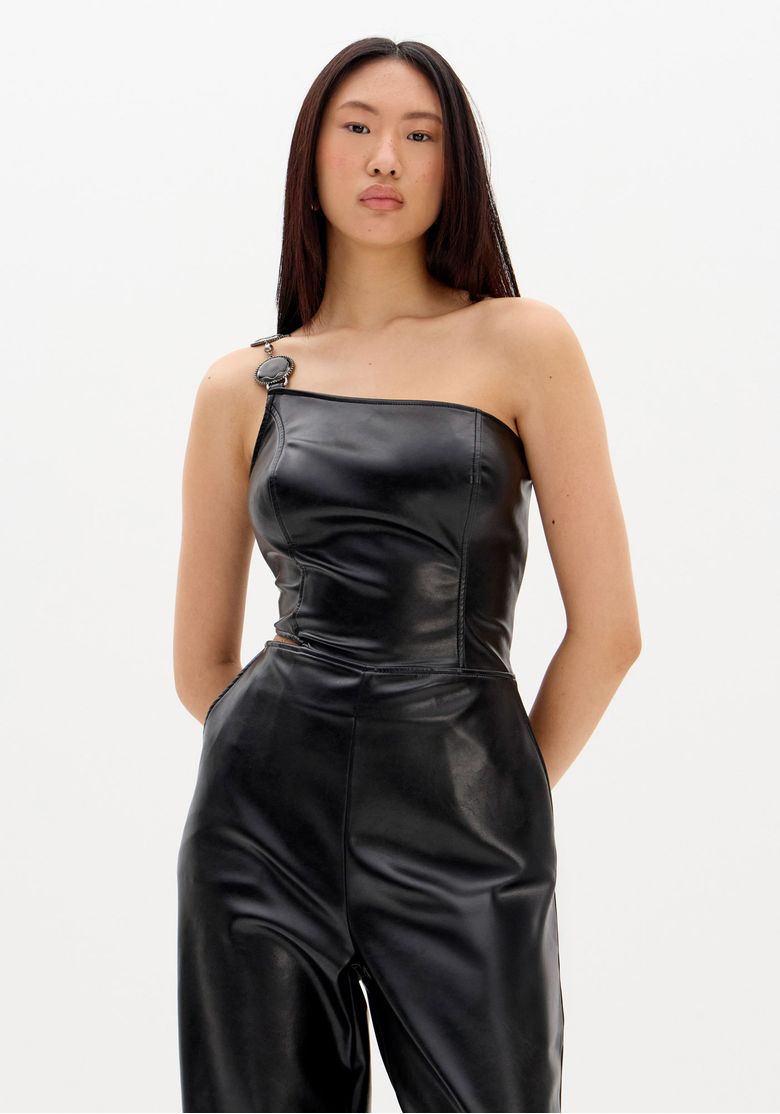 Visão frontal, parte do corpo, do macacão PU preto mostrando ajuste perfeccionista e textura do tecido