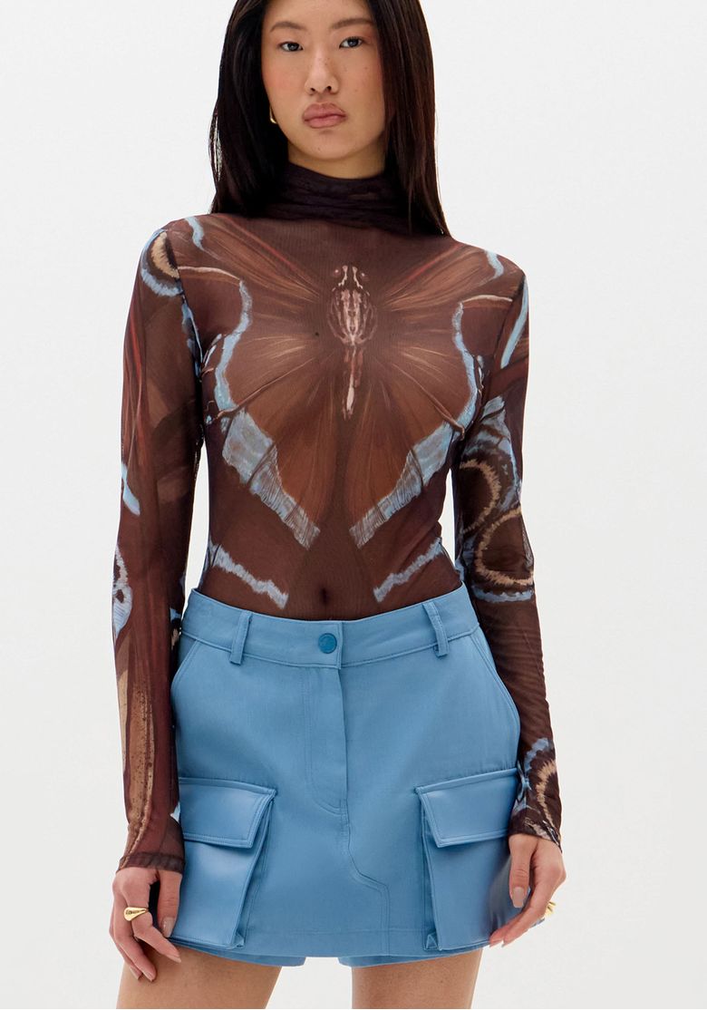 Close-frontal-do-short-saia-azul-mostrando-bolsos-cargo-com-aba-cos-com-passantes-e-botao-no-centro