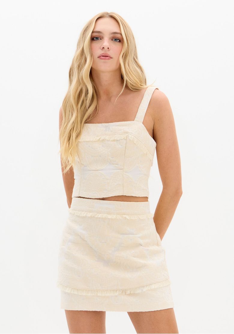 Model wearing a beige textured paisley crop top and matching skirt, front view with wide straps and square neckline
