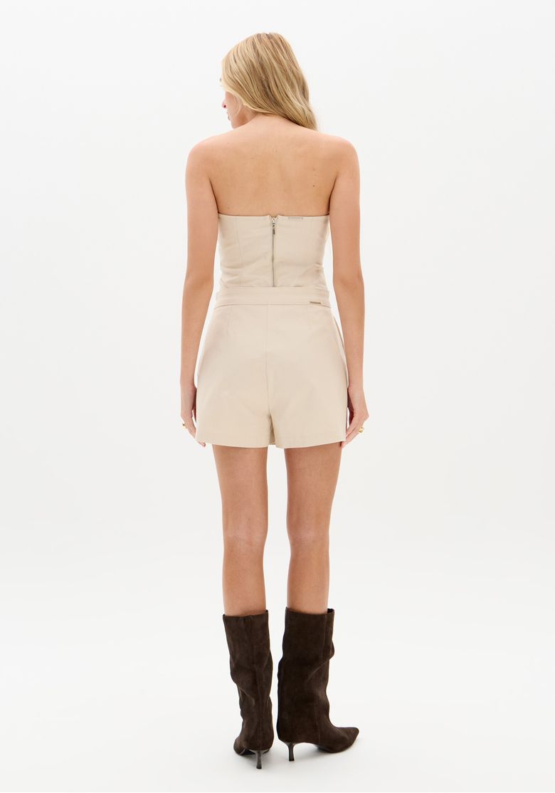 Close-up-da-frente-do-short-saia-bege-com-paineis-estruturados-e-bolsos-funcionais.