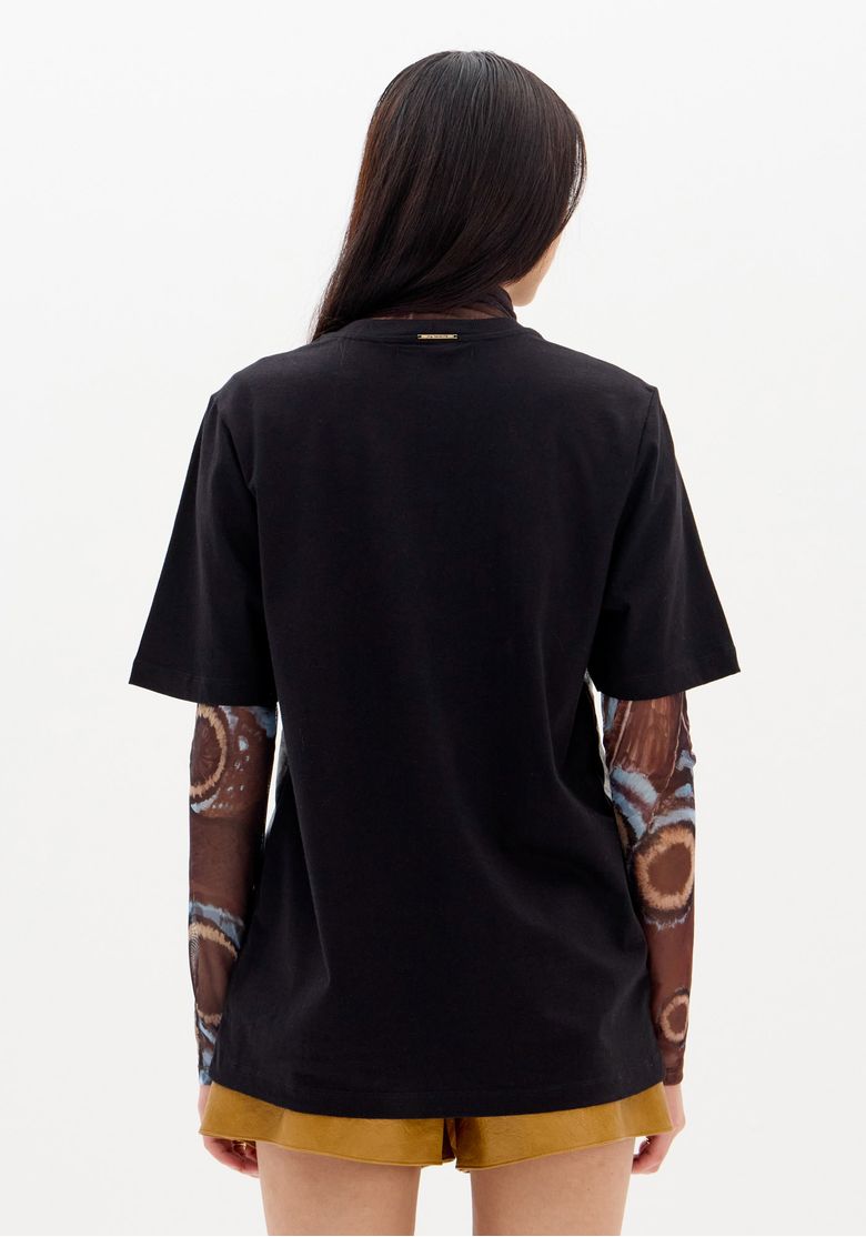 Vista traseira da t-shirt oversized preta com estampa de borboleta.