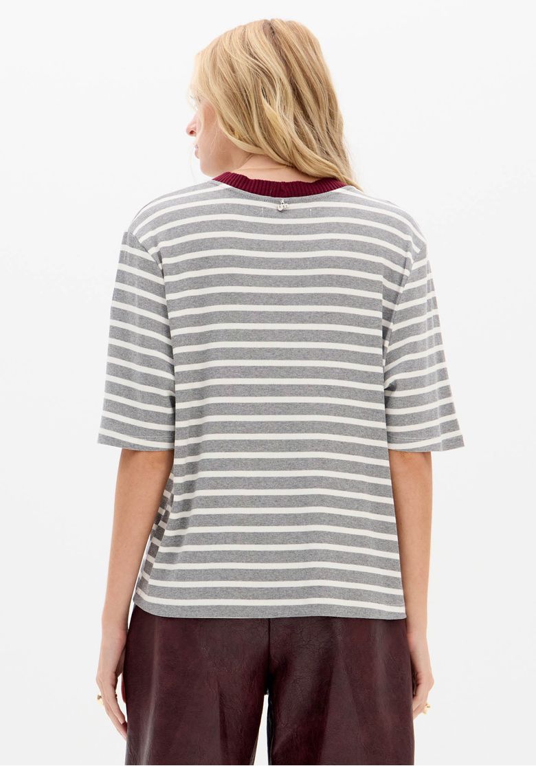Verso da camiseta listrada oversized mostrando listras horizontais cinza e branco e barra reta, modelo de costas
