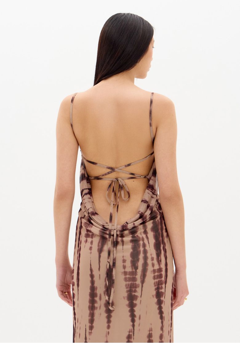 Vestido longo estampado com alças finas e costas abertas com amarração, visto de trás.