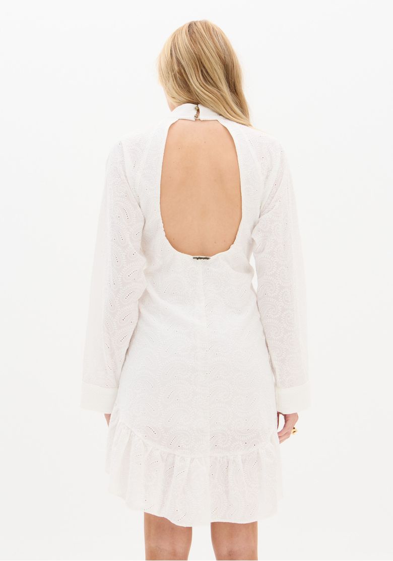 Close das costas abertas do vestido branco em laise e detalhe da barra franzida