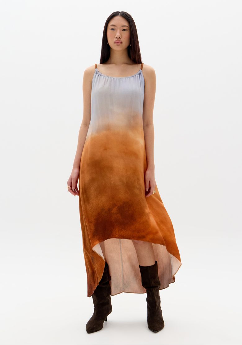 Vestido mullet estampado em tons de marrom e azul, visto de frente, com alças finas e modelagem assimétrica.
