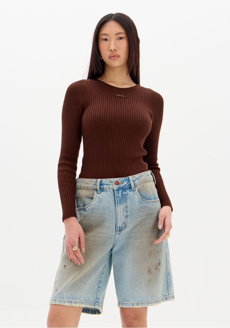 Modelo em pé usando blusa tricô marrom canelada manga longa, vista frontal com bermuda jeans, look casual urbano