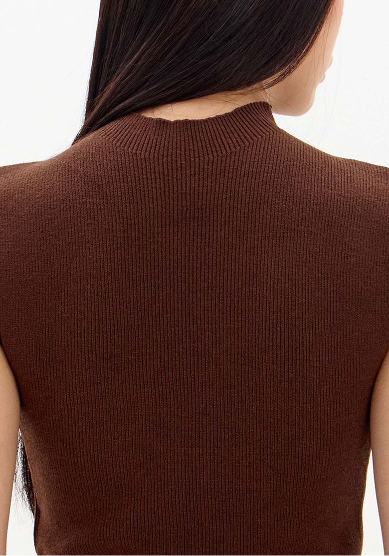 Detalhe do decote gola alta e da malha canelada da blusa tricô marrom, vista próxima do ombro e pescoço