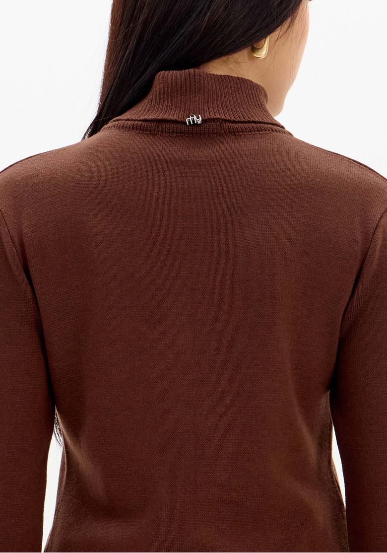 Detalhe da gola alta de uma blusa de tricô marrom, mostrando o aplique metálico no decote e a textura do tecido