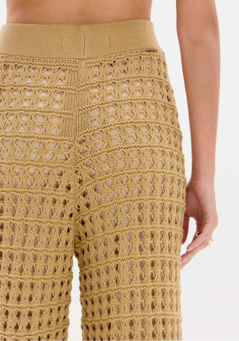 Calça de tricô reta bege vista posterior em fundo branco, mostrando acabamento e bainha reta