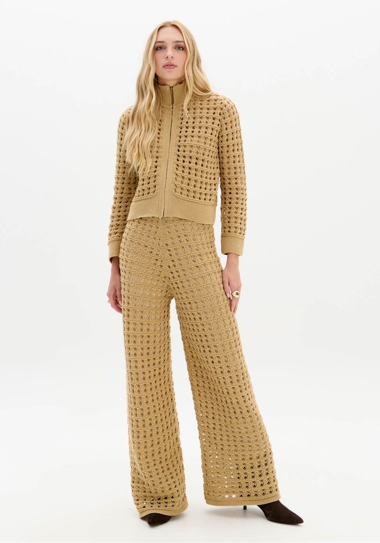 Look inteiro da modelo com jaqueta tricô bege e calça tricot de perna ampla, conjunto coordenado em tom bege para uso casual urbano