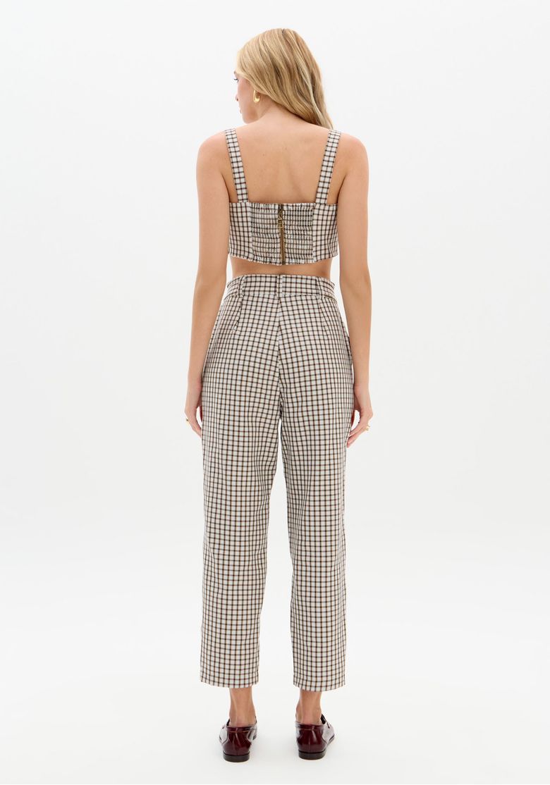 Visao-frontal-do-conjunto--modelo-em-estudio-com-calca-carrot-xadrez-bege-top-cropped-e-mocassim-demonstrando-o-caimento-e-o-comprimento-tornozelo.