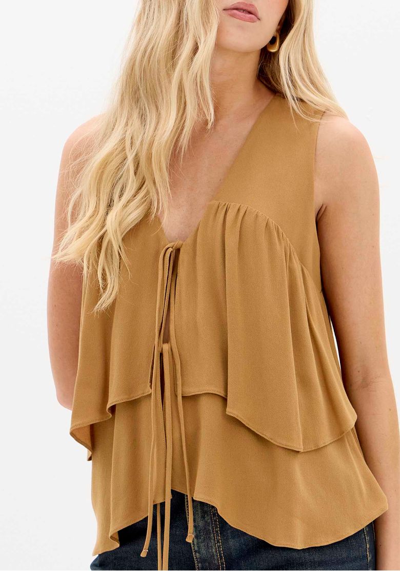Detalhe da amarração frontal e camadas da blusa.