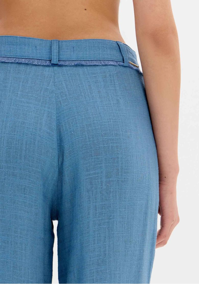 Modelo de frente usando calça wide leg azul com top torcido combinando, comprimento longo e tecido leve