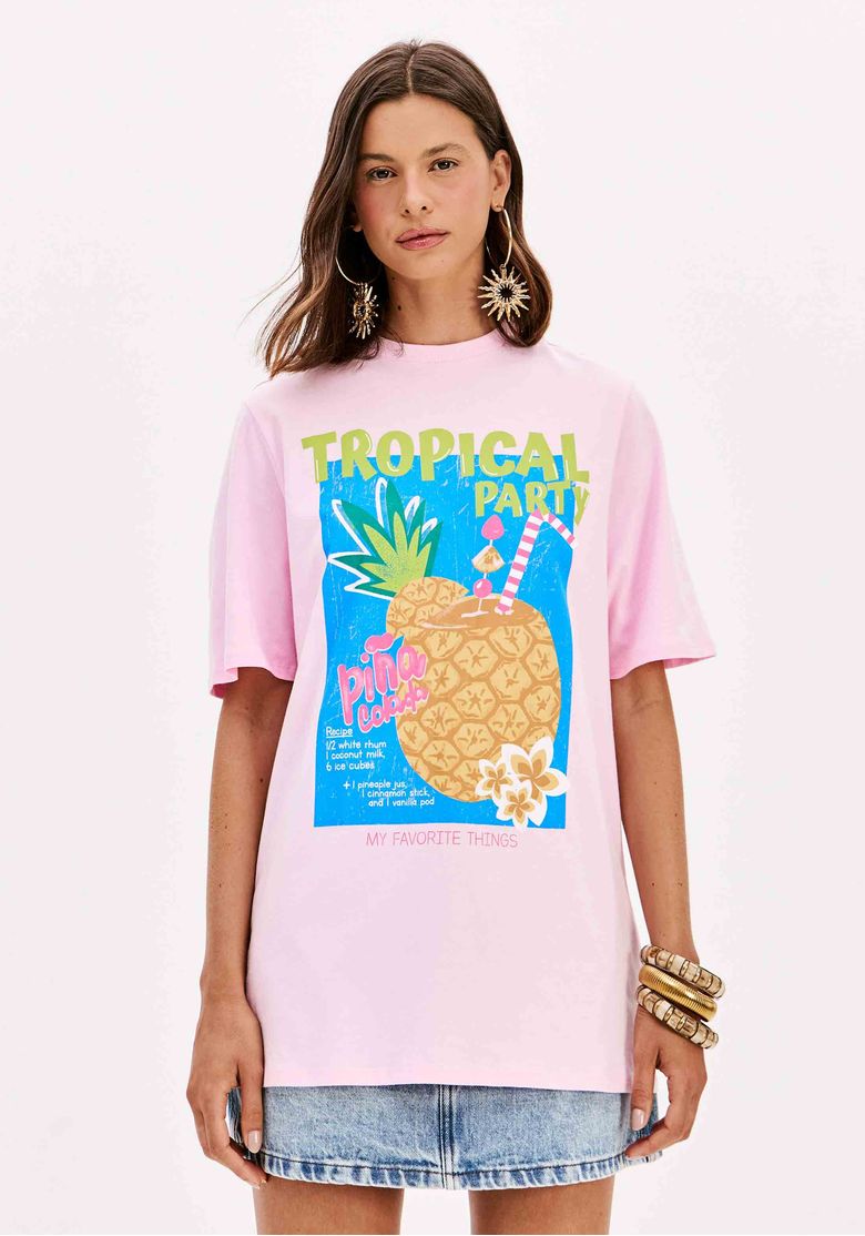 Modelo vestindo t-shirt oversized rosa com estampa, combinada com saia jeans.