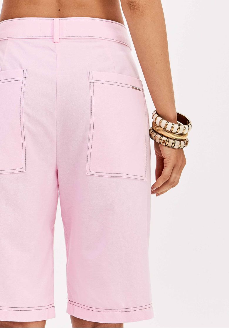 Detalhe dos bolsos traseiros da bermuda rosa.