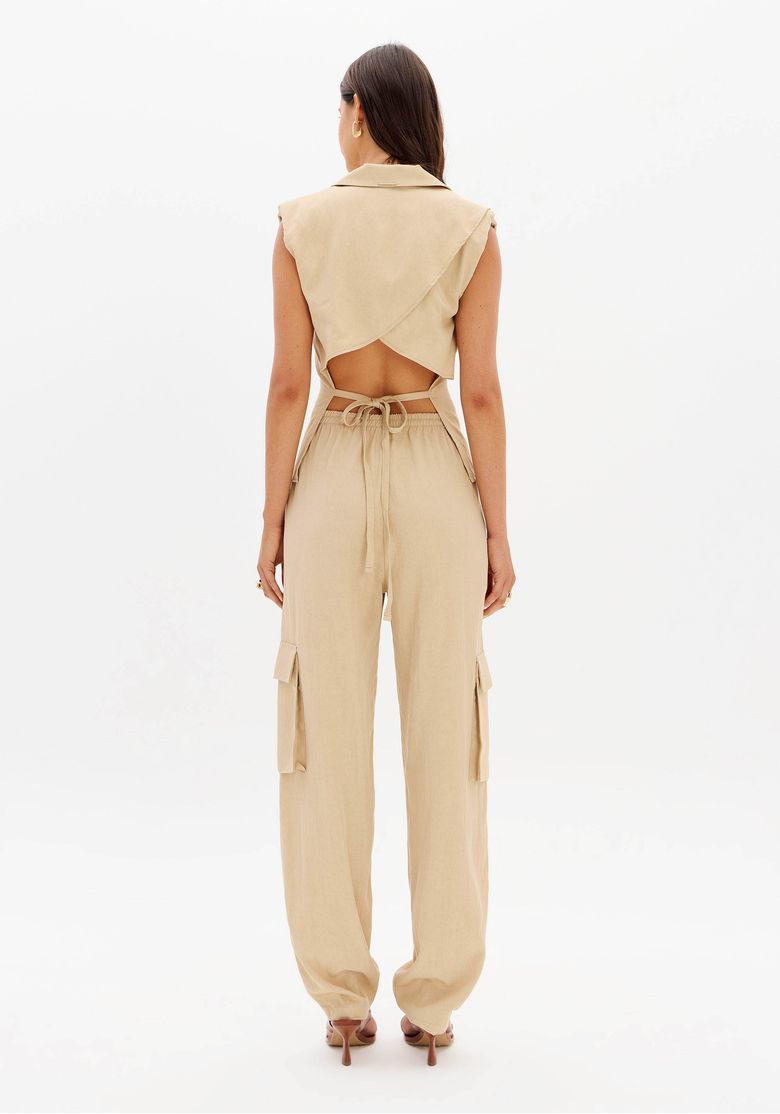 Close frontal da calça marrom com destaque para o cós elástico e os bolsos utilitários laterais com aba