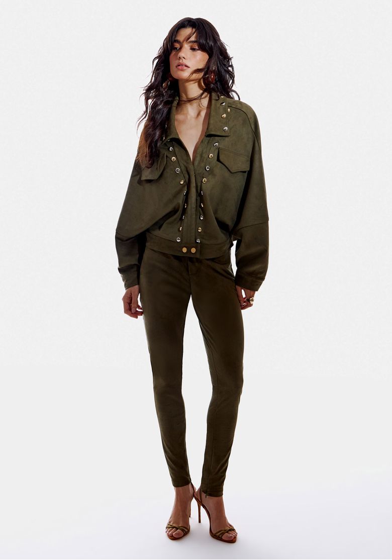 Calça skinny suede verde musgo vista frontal em modelo, cintura média e caimento justo até o tornozelo