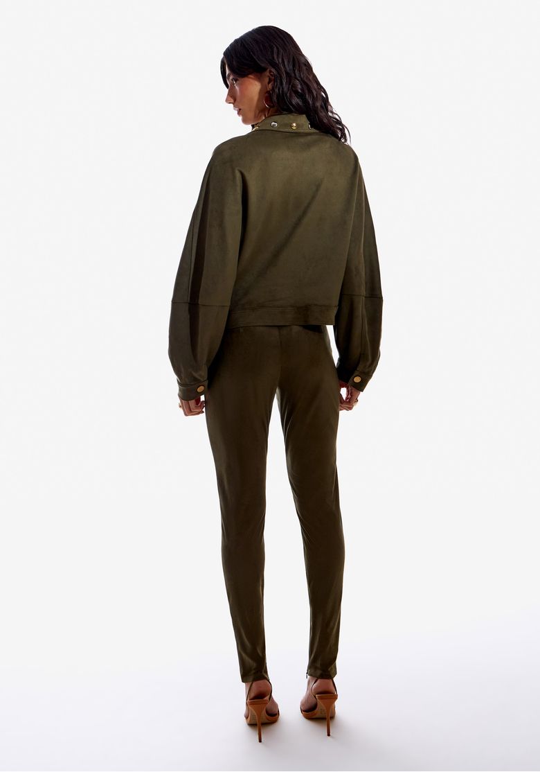 Calça skinny suede verde musgo vista traseira mostrando cós com passantes e caimento ajustado