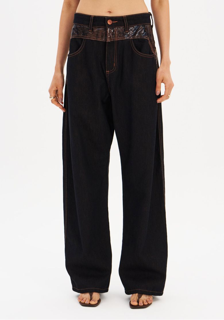 Calça jeans carpenter preta vista frontal em close médio mostrando fechamento por zíper e botão, passantes no cós e costura contrastante