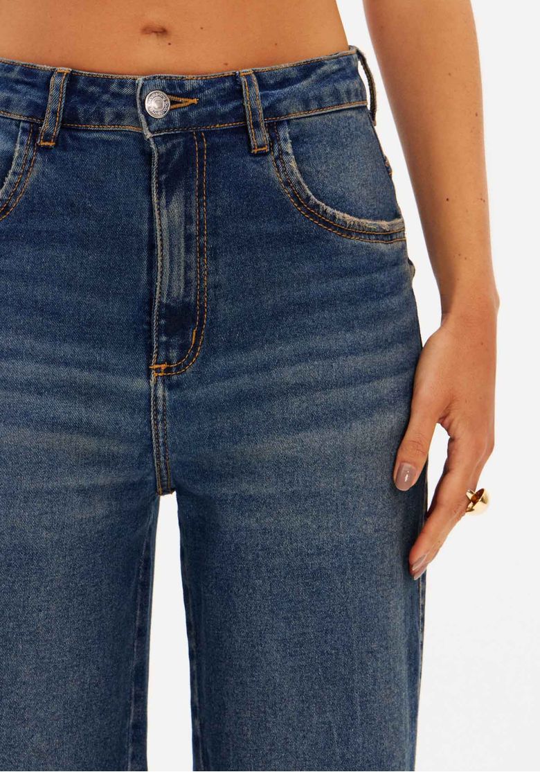 Detalhe do cós da calça jeans, mostrando os passantes e a lavagem escura.