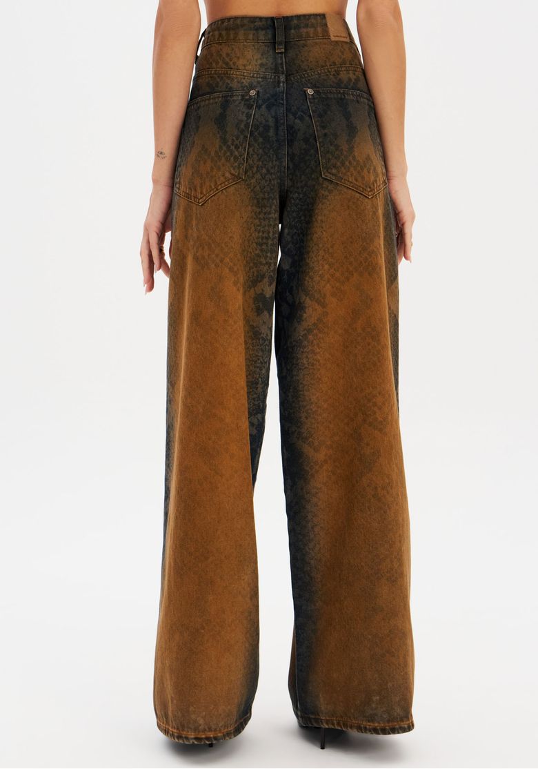 Imagem de costas da modelo com calça jeans marrom e estampa snake mostrando o corte relaxado e cintura média.