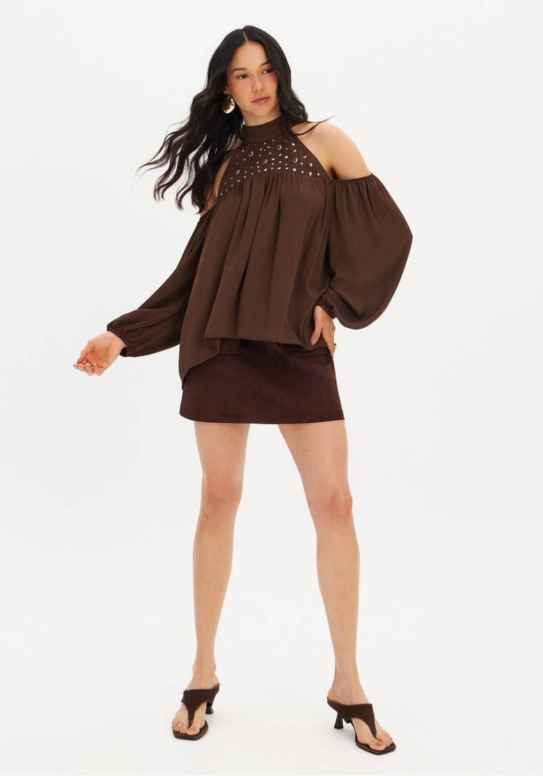 Modelo-vestindo-blusa-fluida-marrom-com-mangas-longas-e-detalhes-em-rebite-vista-frontal.