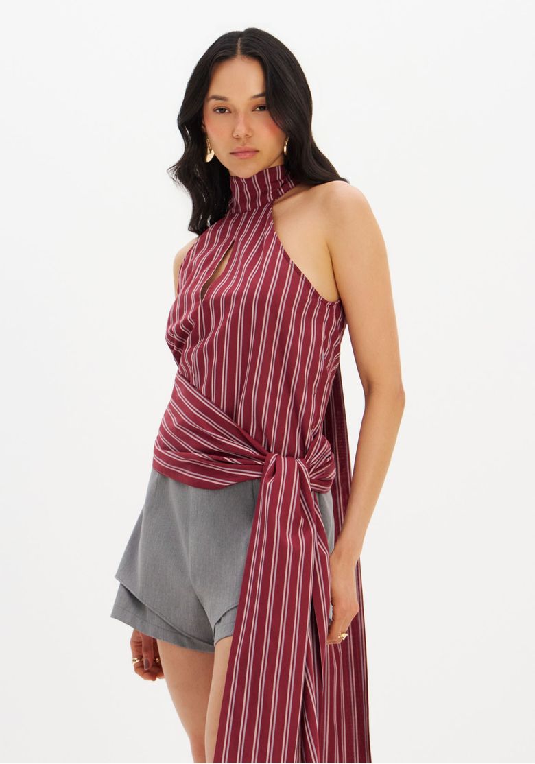 Blusa-gola-alta-listrada-vermelha-vista-tres-quartos-com-amarracao-na-cintura-e-faixa-longa-look-com-shorts-cinza
