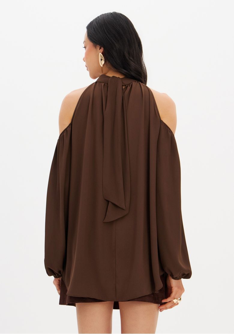 Vista-completa-da-blusa-fluida-marrom-em-um-look-casual-com-saia-curta.