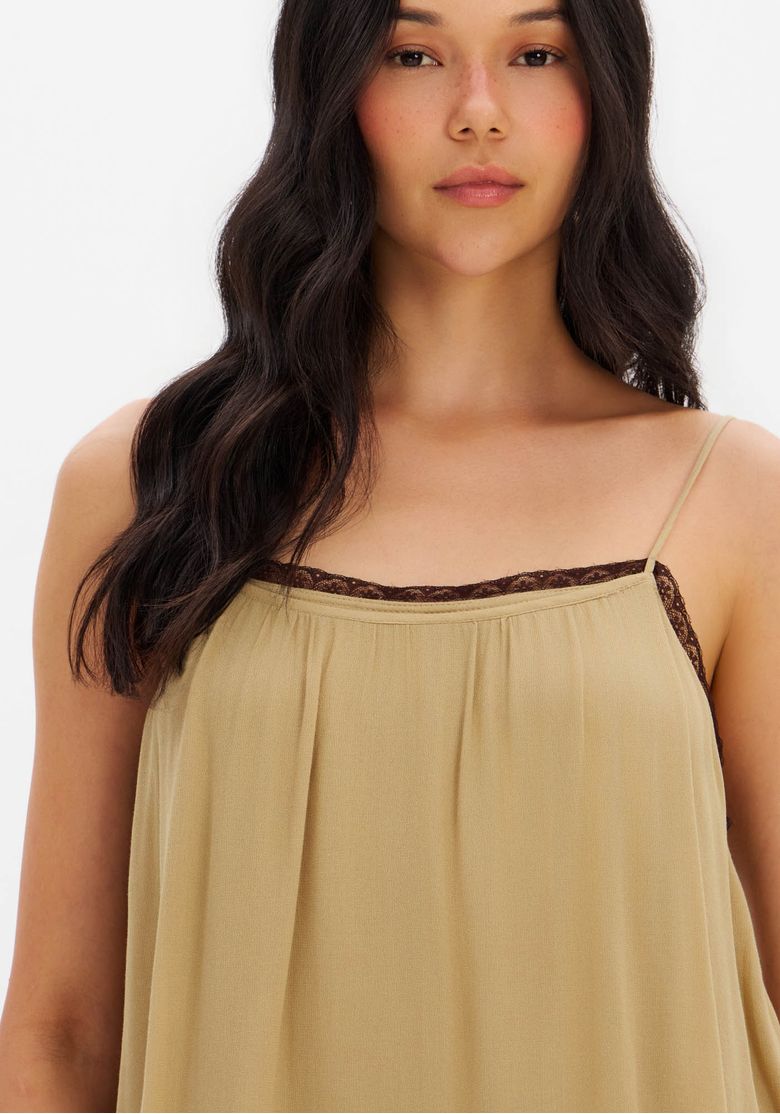 Vista-posterior-da-blusa-ampla-de-viscose-bege-com-camadas-de-babados-e-alcas-finas-destacando-o-caimento-solto.