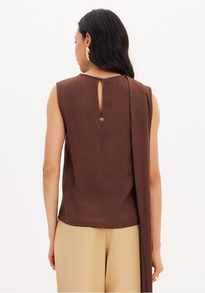 Look completo frontal: blusa sem manga marrom em linho com capa fluida combinada a calça pantalona bege, styling boho-chic