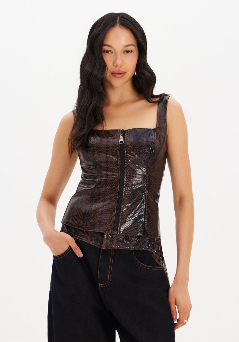 Modelo usando blusa corset PU marrom com estampa croco e zíper frontal em pose 3/4, alças largas e acabamento brilhante
