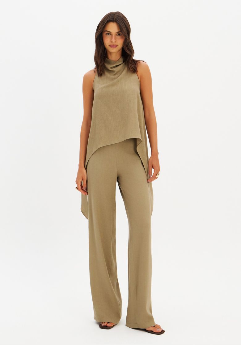 Look completo frontal: blusa assimétrica verde combinada com calça pantalona de perna larga, look alongado para office