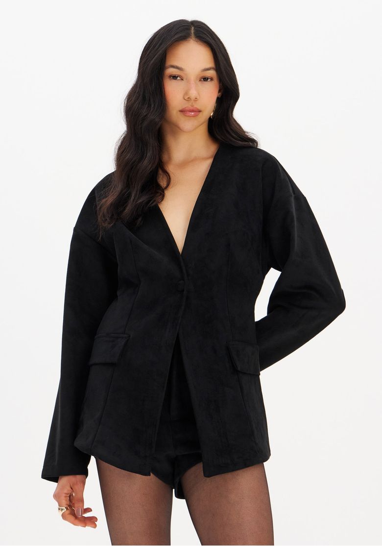 Visão frontal do look completo com blazer ajustado de suede preto sobre shorts, modelagem ajustada e mangas longas em fundo branco