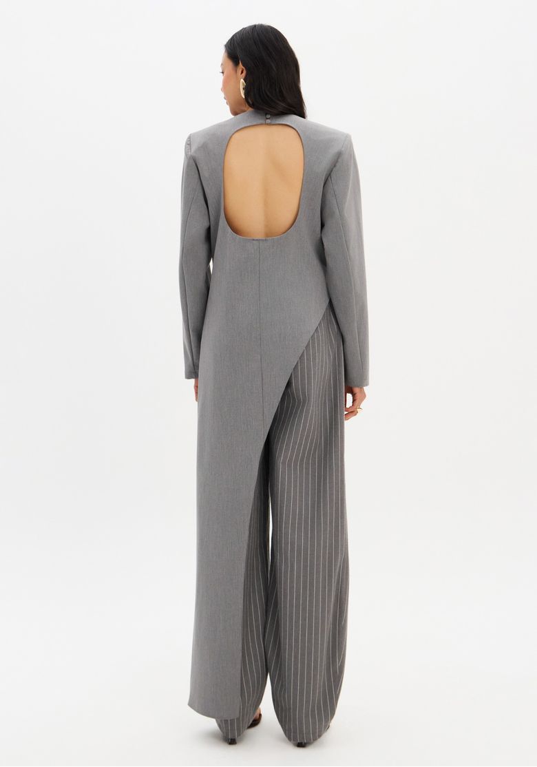 Vista traseira full body da blusa cinza com abertura oval nas costas e sobreposição assimétrica, fechamento por botões no pescoço.