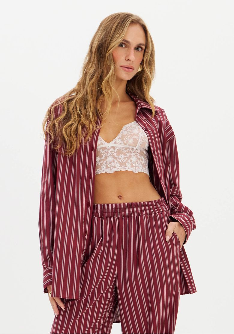 Camisa oversized alongada com listras verticais em vermelho e branco, vista frontal com mangas longas.