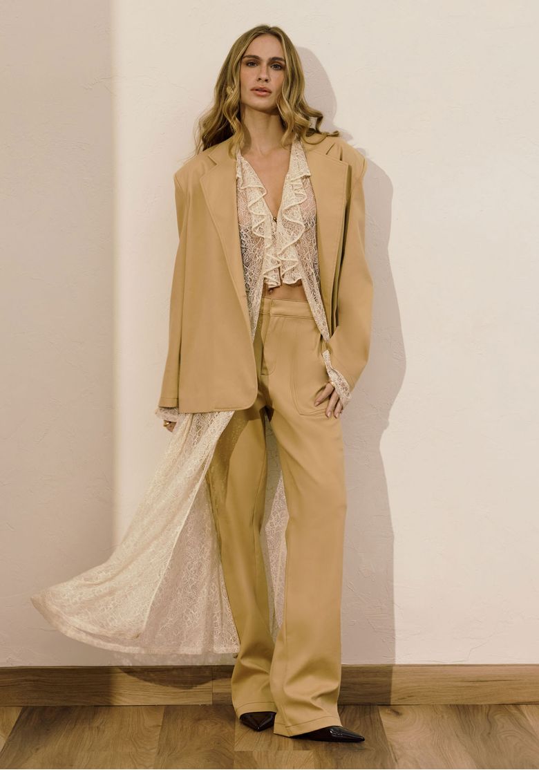Modelo vestindo calça reta utilitária bege com blazer oversize e blusa de renda, look editorial e moderno