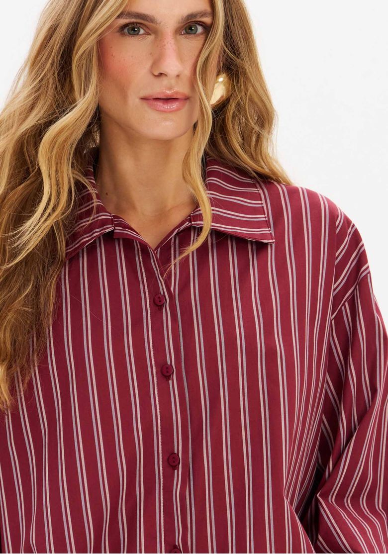 Vista traseira da camisa oversized alongada, mostrando a barra arredondada e o padrão de listras.