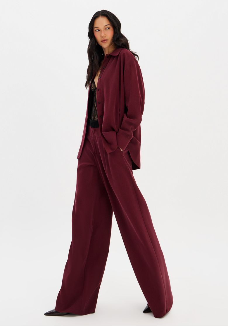 Modelo vestindo calça full length bordô com blazer combinando, vista frontal.